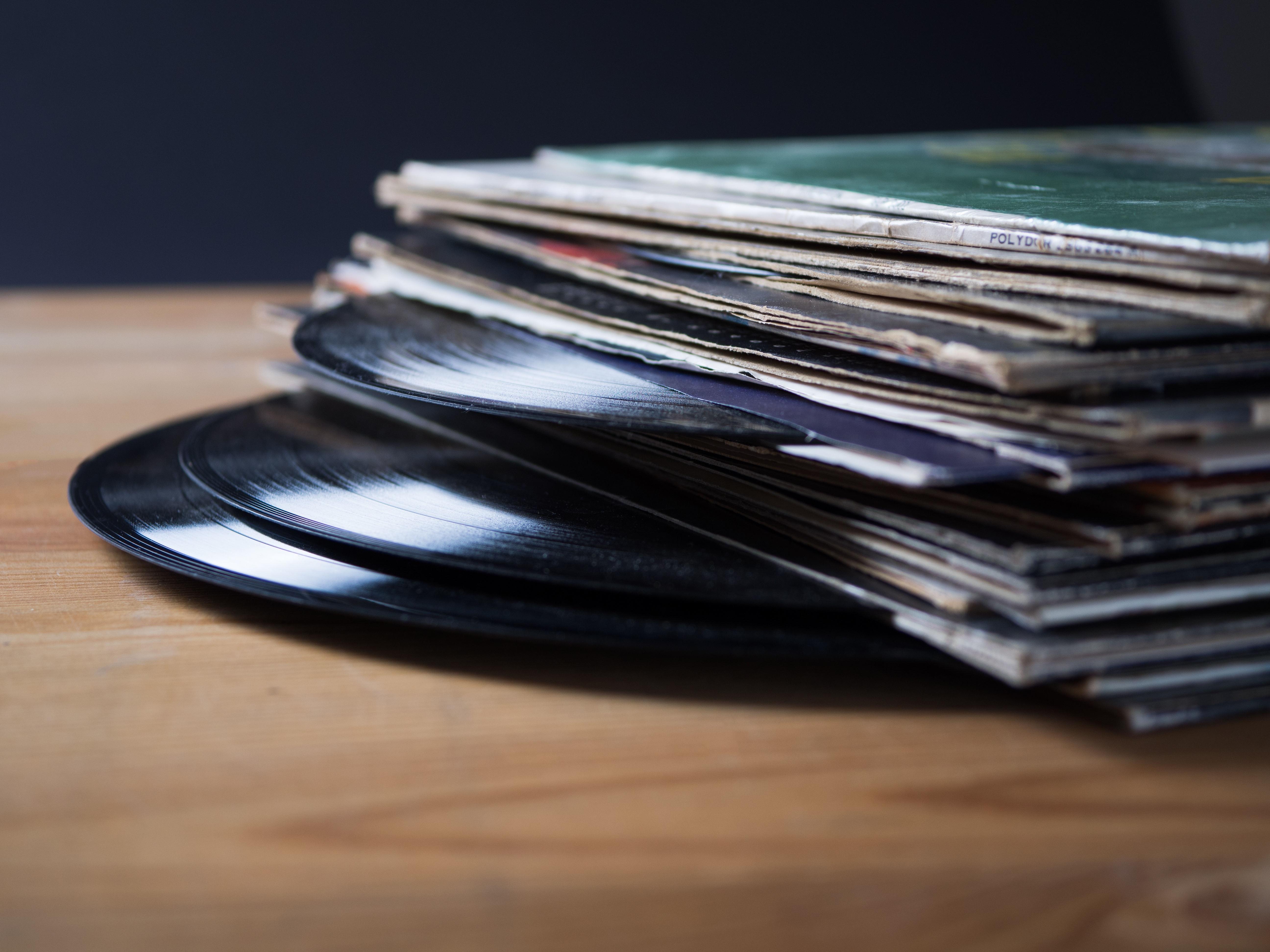 Vinyl records stacked on a table.